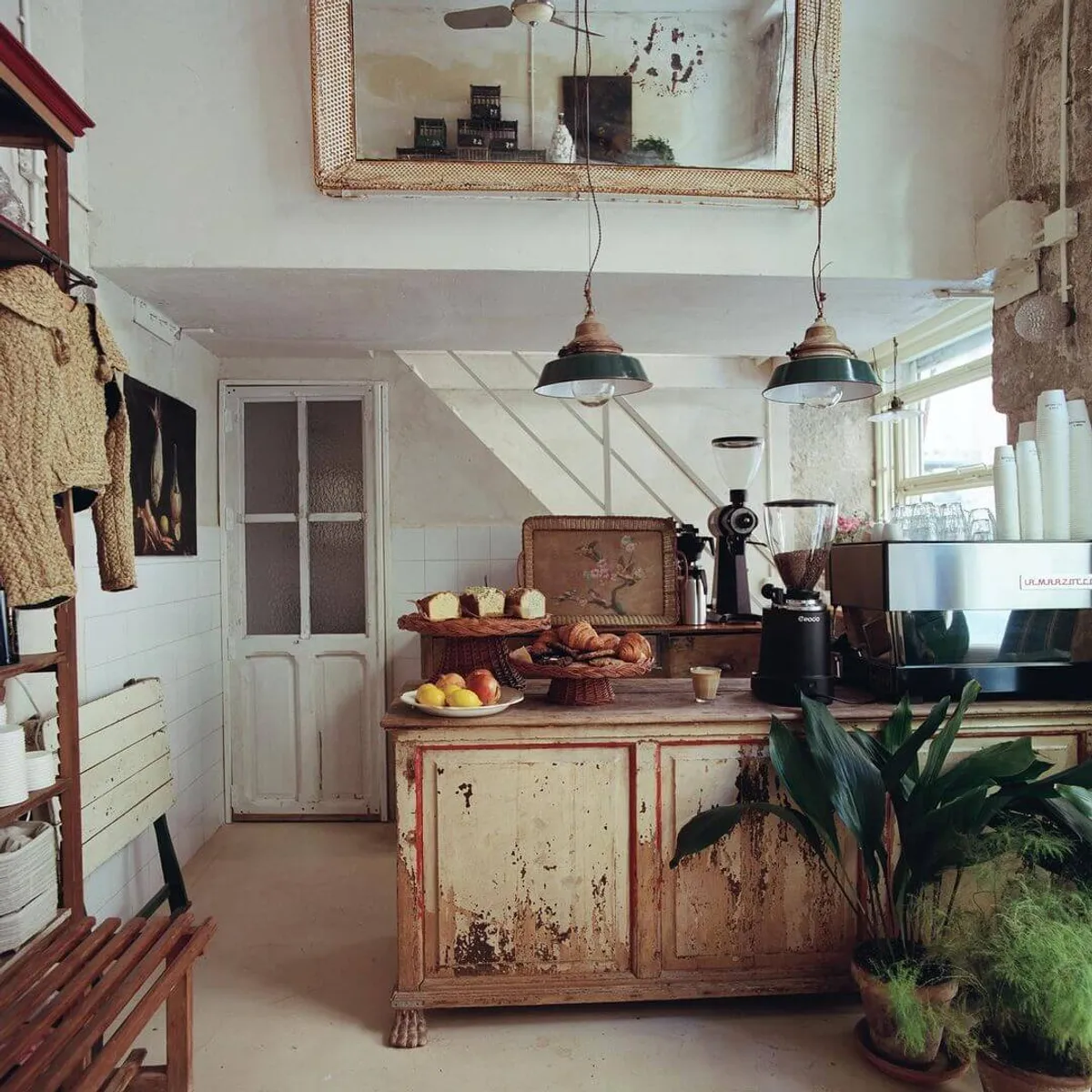 Rustic interior of Pan y Pepinillos cafe in Madrid featuring a weathered wooden service counter, vintage lighting, and fresh pastries—a quiet and inspiring atmosphere for those searching for unique study spots in Madrid.