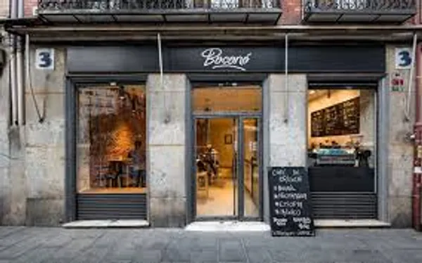 Industrial-style storefront of Boconó Specialty Coffee, a modern cafe in Madrid with large glass windows and minimalist signage, known as one of the top laptop-friendly study spots in Madrid for students and remote workers.