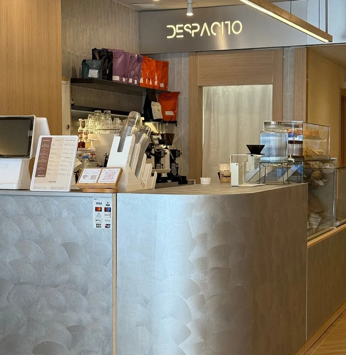 Sleek gray service counter at Despacito Coffee, a minimalist specialty cafe in Madrid with digital menus and a clean, organized layout, ideal for remote workers searching for modern study spots in Madrid.